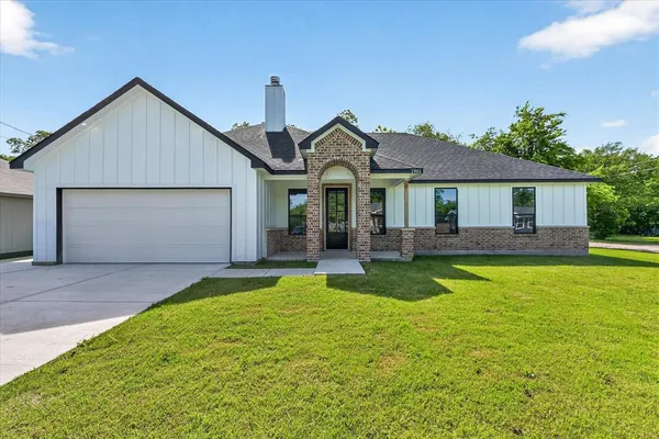 a front view of a house with a garden and yard