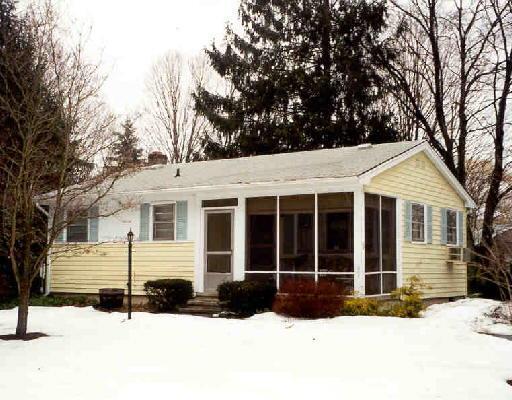 a front view of a house with a yard covered in snow