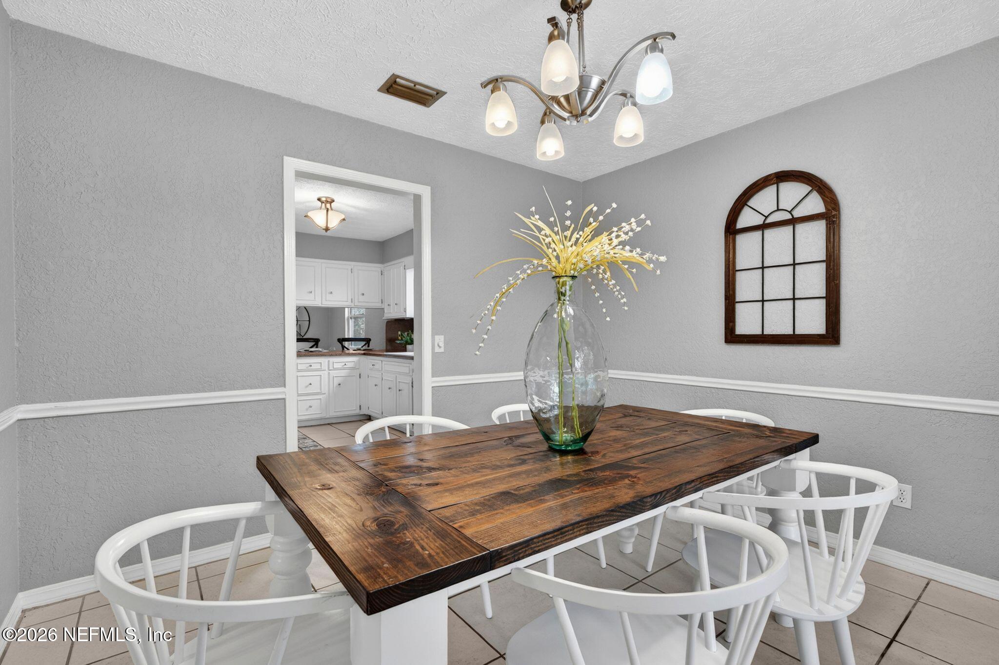 138 Ridgefield Court Orange Park, FL 32065 - Photo 17 of 64 a dining room with wooden floor a chandelier a wooden table and chairs