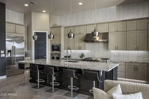 a kitchen with stainless steel appliances granite countertop a sink and a refrigerator