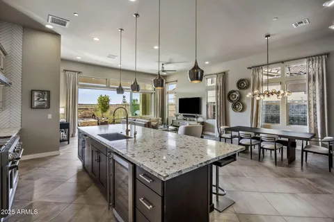 a kitchen with stainless steel appliances granite countertop a kitchen island a stove a table and chairs