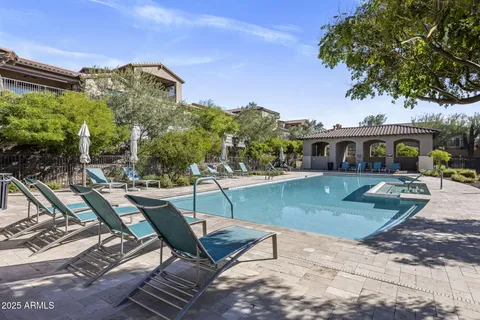 a view of a swimming pool with lounge chairs in patio