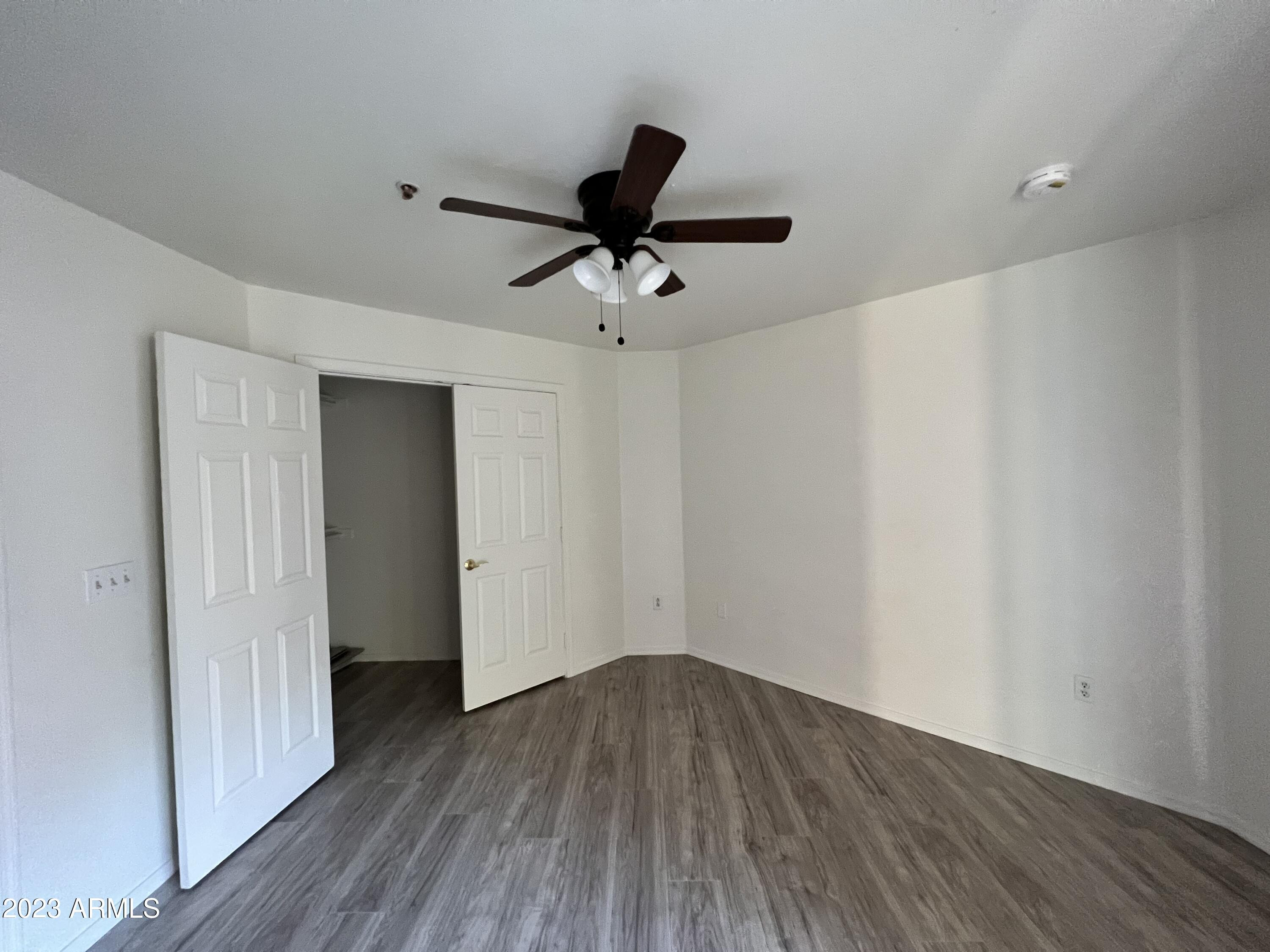1287 North Alma School Road, Unit 224 Chandler, AZ 85224 - Photo 6 of 8 a view of a livingroom with a hardwood floor and a ceiling fan