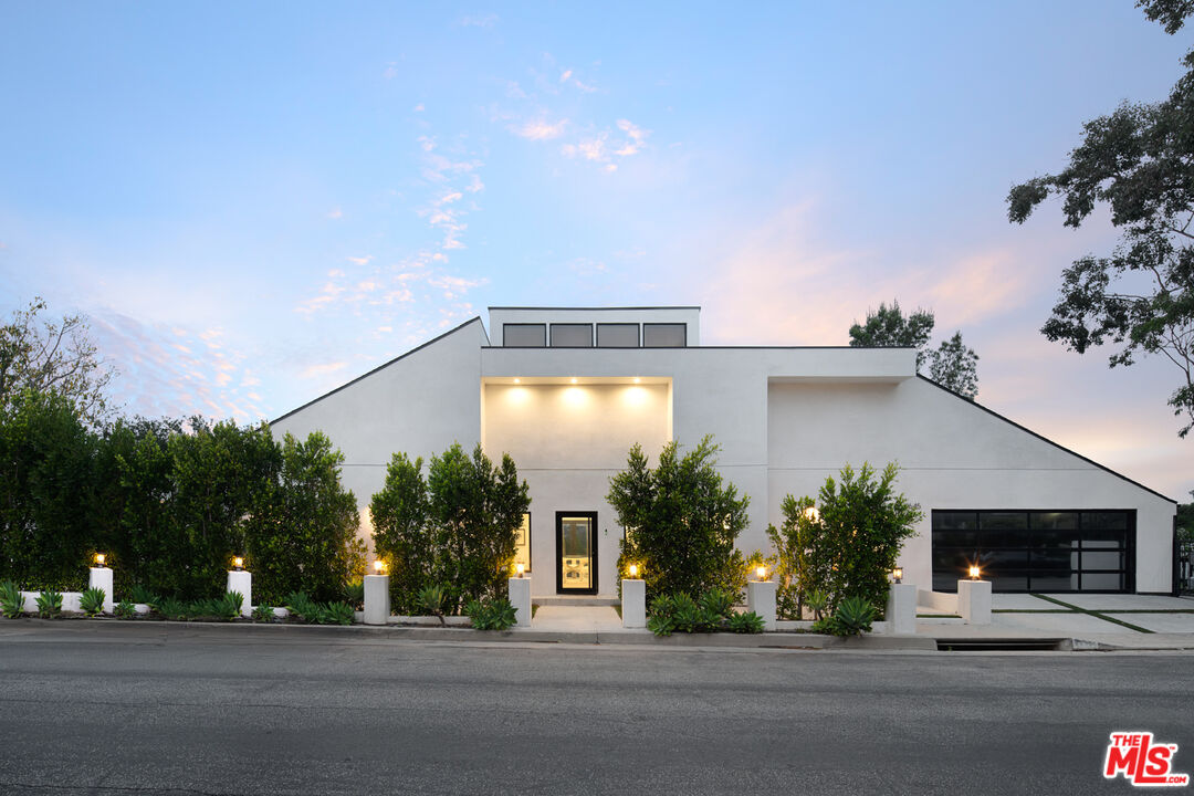9645 Highridge Drive Beverly Hills, CA 90210 - Photo 1 of 29 a front view of a house with a yard and garage
