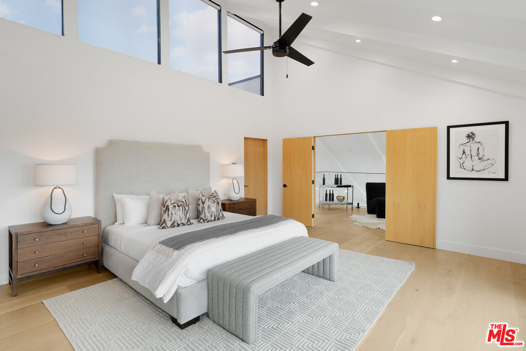 9645 Highridge Drive Beverly Hills, CA 90210 - Photo 14 of 29 a bedroom with a bed couch and painting on the wall