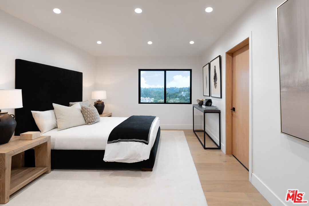 9645 Highridge Drive Beverly Hills, CA 90210 - Photo 19 of 29 a spacious bedroom with a bed and a flat screen tv