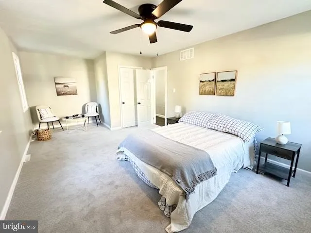 a spacious bedroom with a bed and ceiling fan