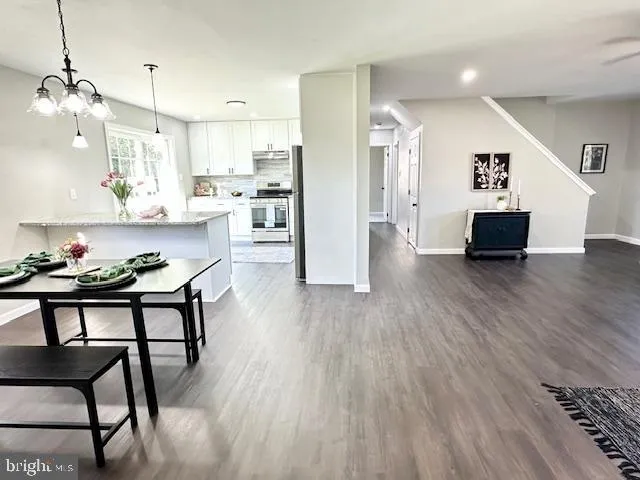 a kitchen with stainless steel appliances kitchen island hardwood floor and a sink