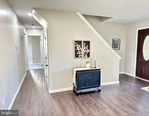 a view of a hallway with wooden floor and stairs