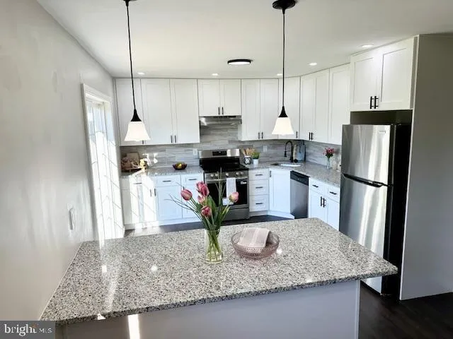 a kitchen with stainless steel appliances granite countertop a sink refrigerator and microwave