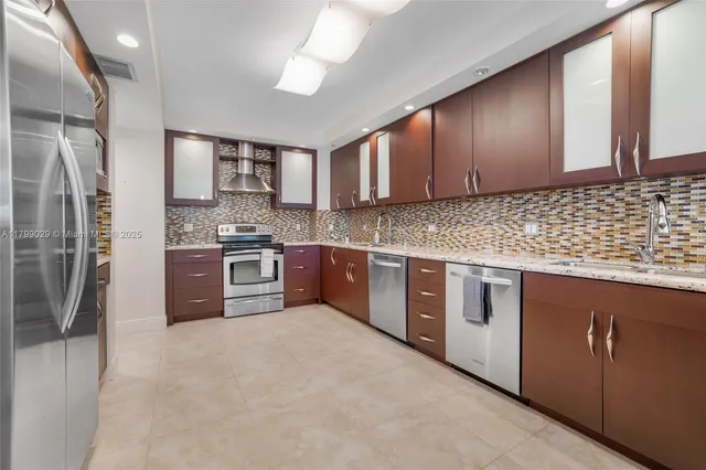 a kitchen with stainless steel appliances granite countertop a stove a sink dishwasher a refrigerator and a microwave oven