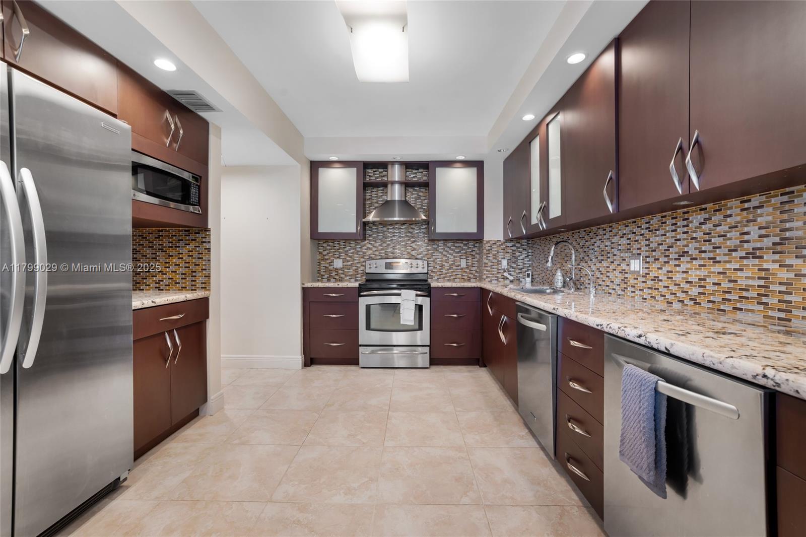 9801 Collins Avenue, Unit 5S Bal Harbour, FL 33154 - Photo 13 of 32 a large kitchen with stainless steel appliances granite countertop a stove a sink and a refrigerator