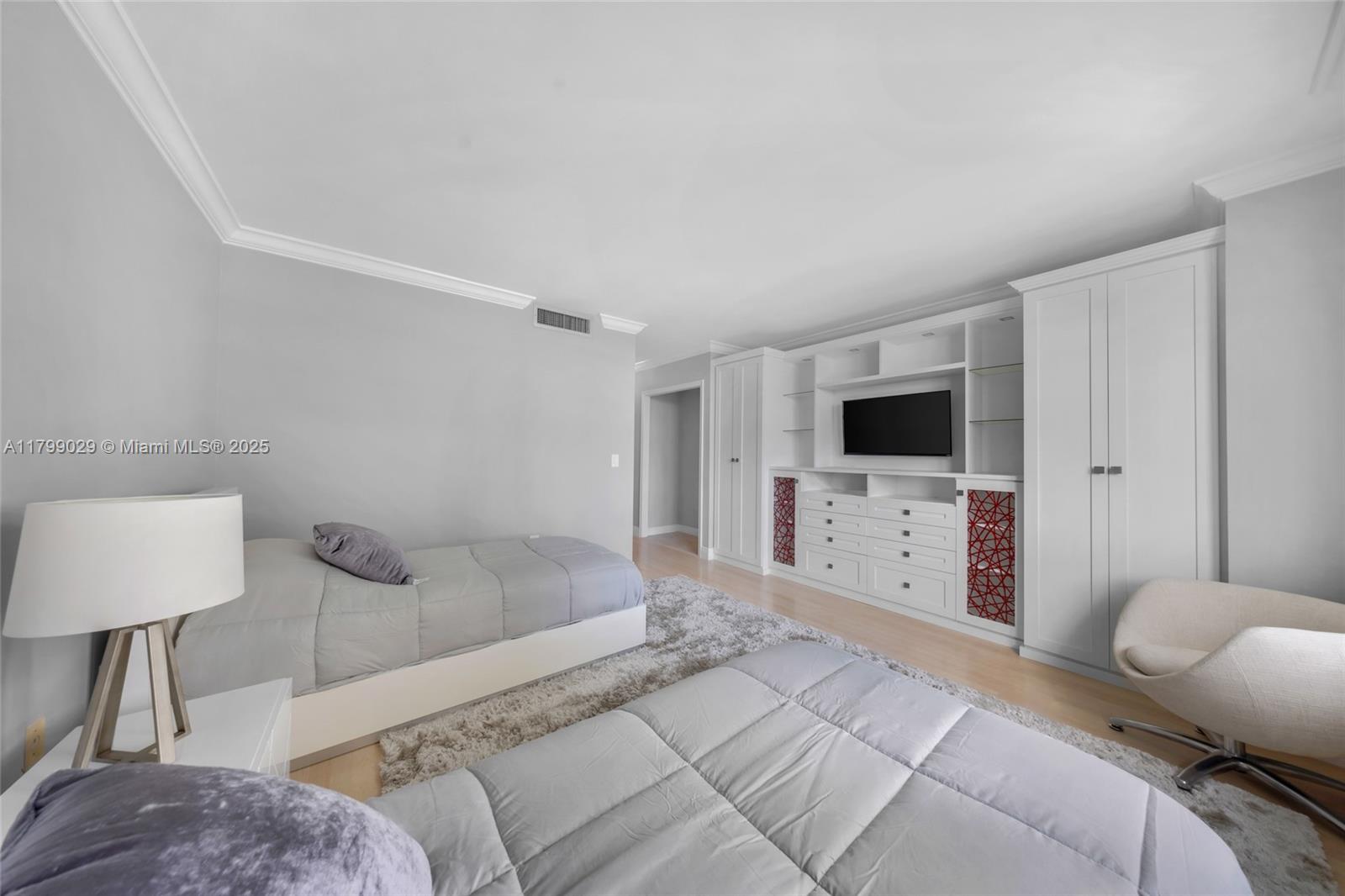 9801 Collins Avenue, Unit 5S Bal Harbour, FL 33154 - Photo 20 of 32 a spacious bedroom with a bed and a flat screen tv