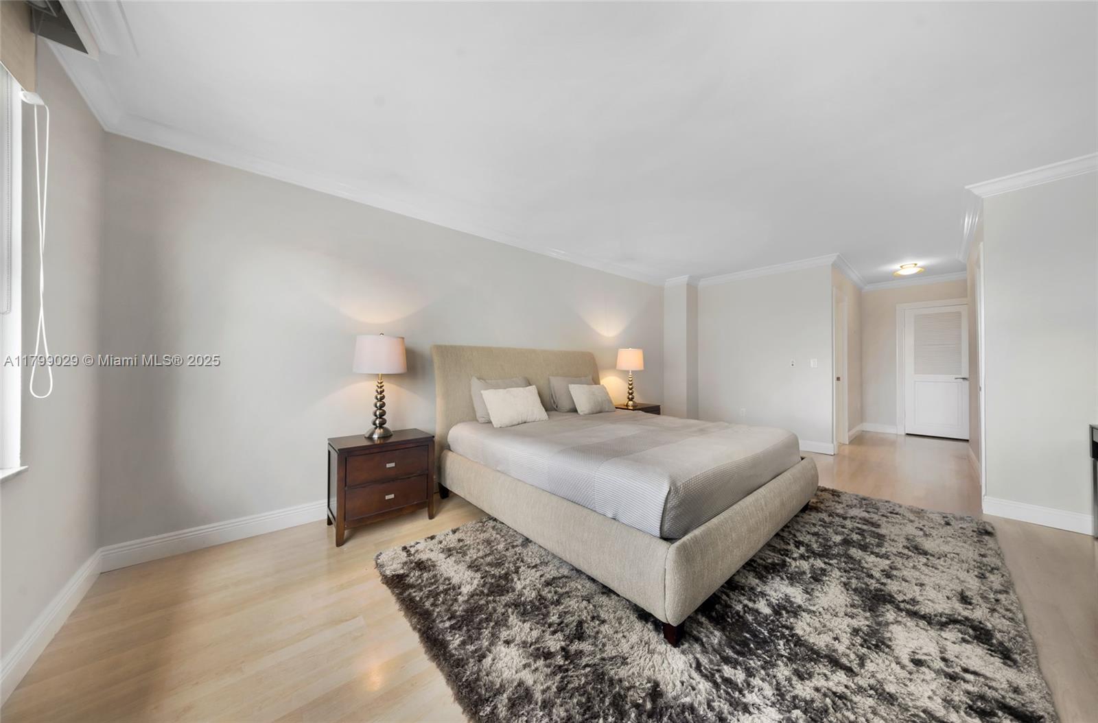 9801 Collins Avenue, Unit 5S Bal Harbour, FL 33154 - Photo 26 of 32 a bedroom with a bed and a lamp