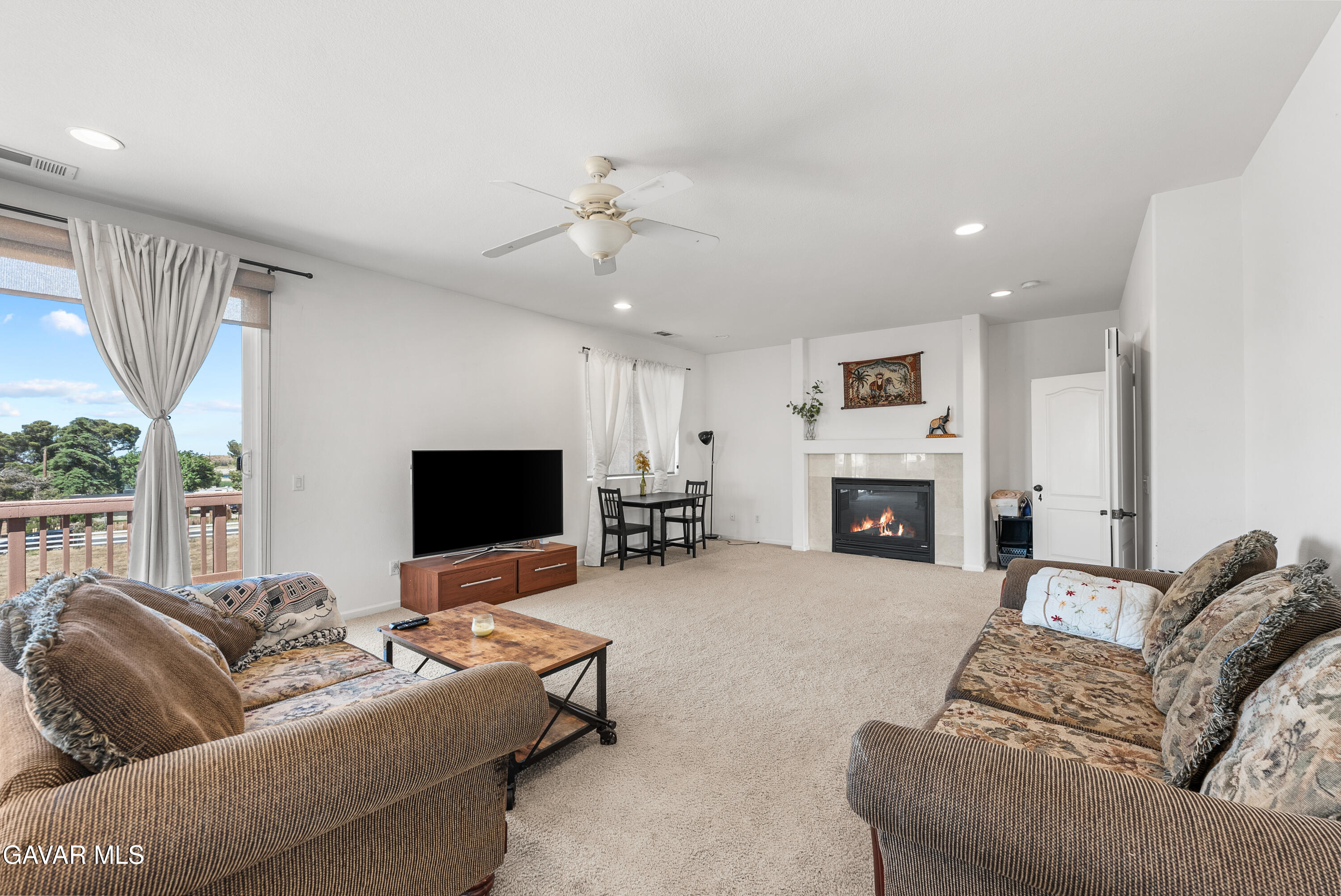 658 Lago Lindo Road Palmdale, CA 93550 - Photo 54 of 91 a living room with furniture a fireplace and a flat screen tv