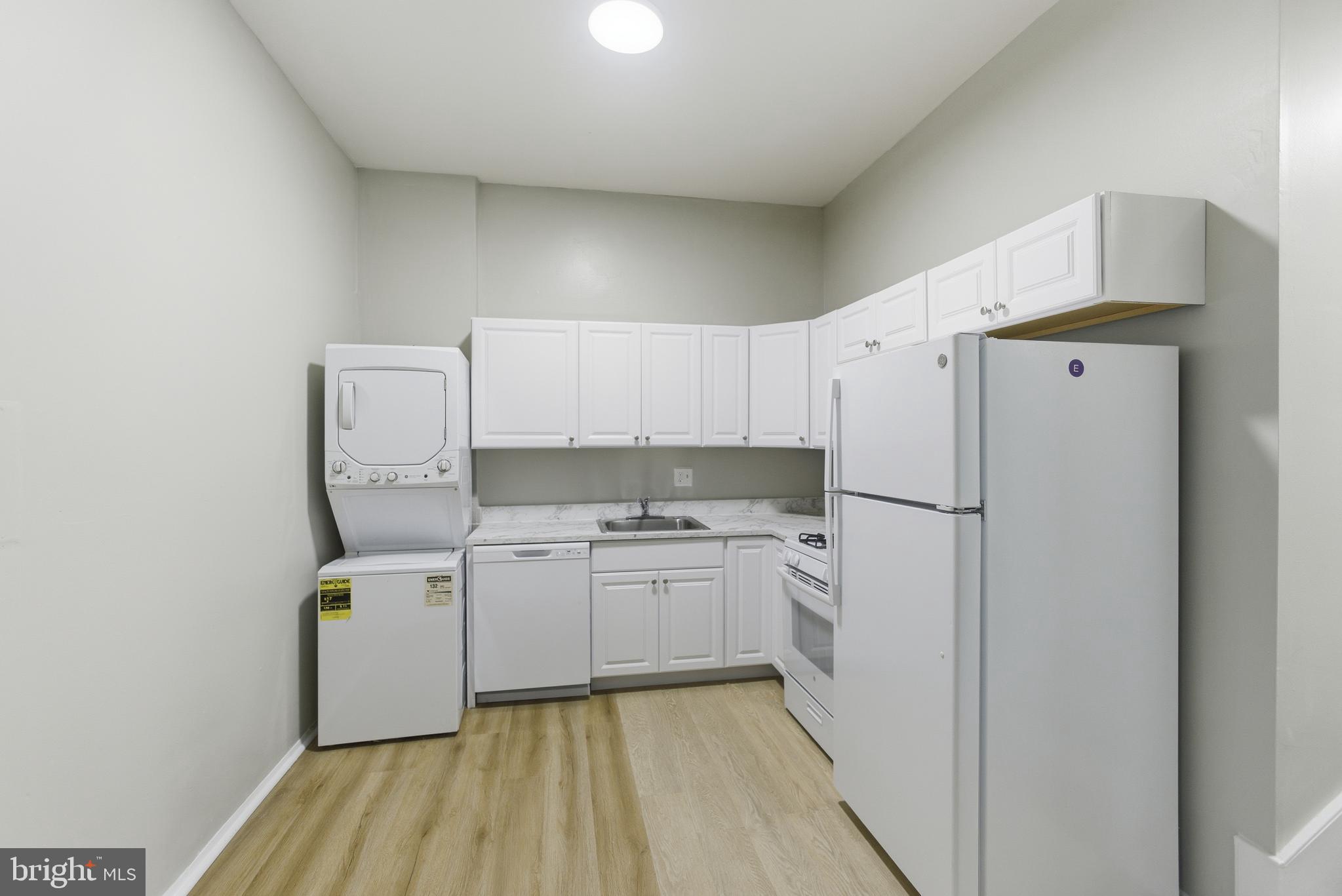18806 Walkers Choice Road, Unit 2 Montgomery Village, MD 20886 - Photo 11 of 18 a kitchen with a refrigerator a stove and wooden floor