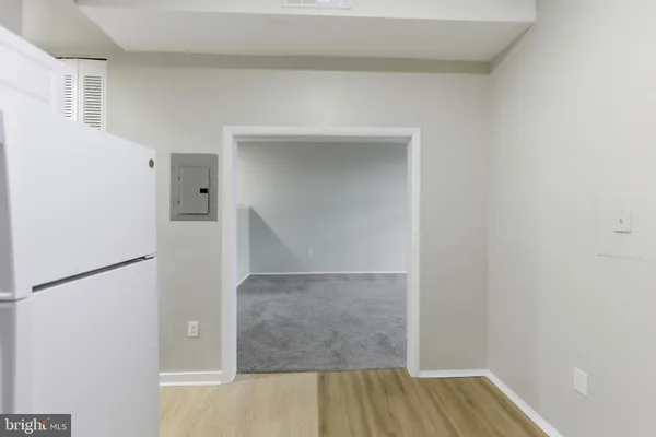 a view of hallway with wooden floor and cabinet