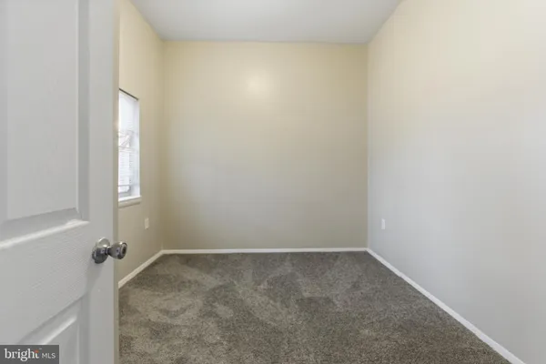 an empty room with kitchen and windows