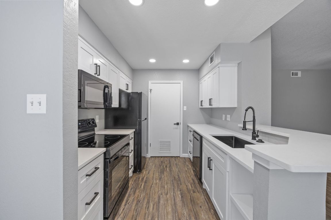 4711 Spicewood Springs Road, Unit 106 Austin, TX 78759 - Photo 9 of 23 a kitchen with stainless steel appliances a sink stove and refrigerator