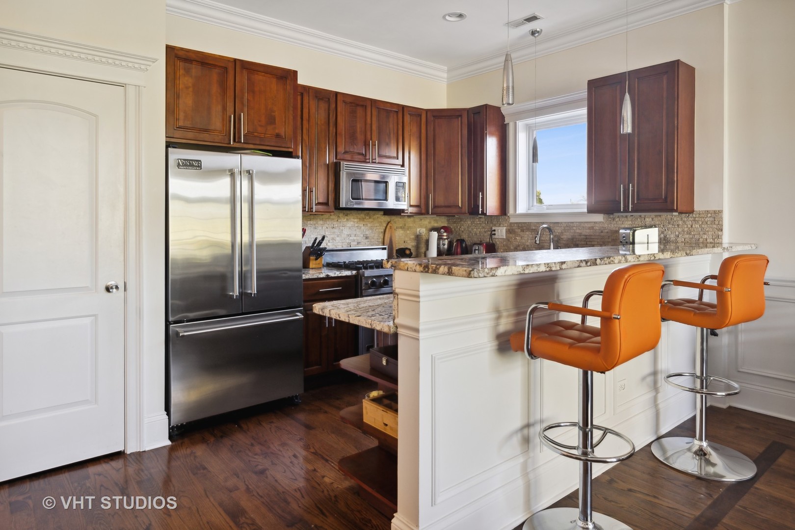 4880 North Clark Street, Unit 2B Chicago, IL 60640 - Photo 5 of 15 a kitchen with stainless steel appliances granite countertop a refrigerator a sink a stove a dining table and chairs