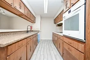 a kitchen with stainless steel appliances granite countertop a sink and a wooden floors