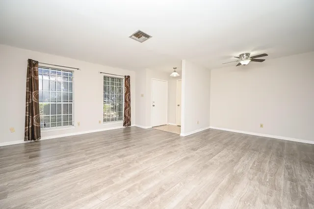 wooden floor in an empty room with a window