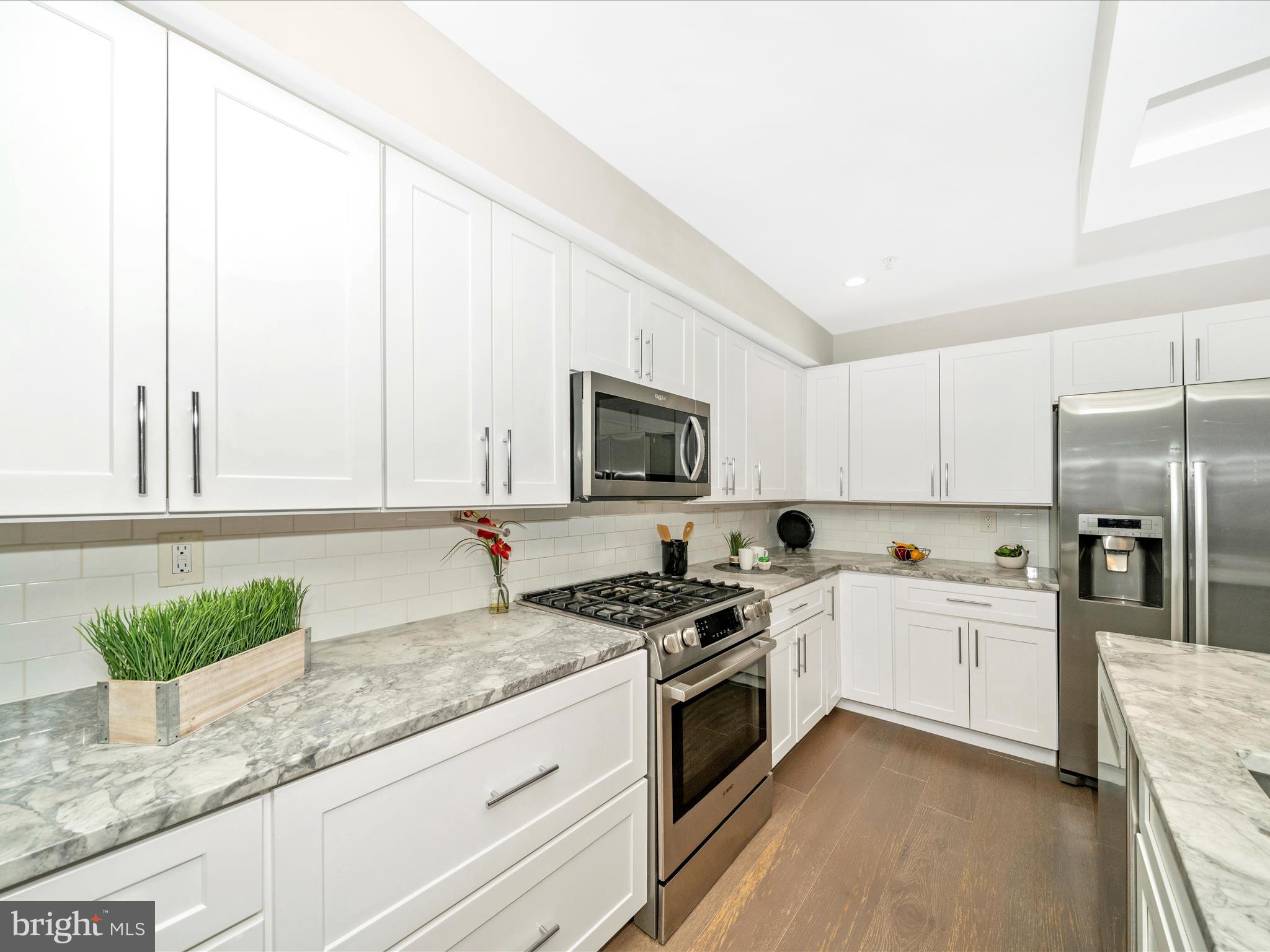 1826 Independence Avenue Southeast, Unit 4 Washington, DC 20003 - Photo 9 of 53 a kitchen with granite countertop a sink a stove and cabinets