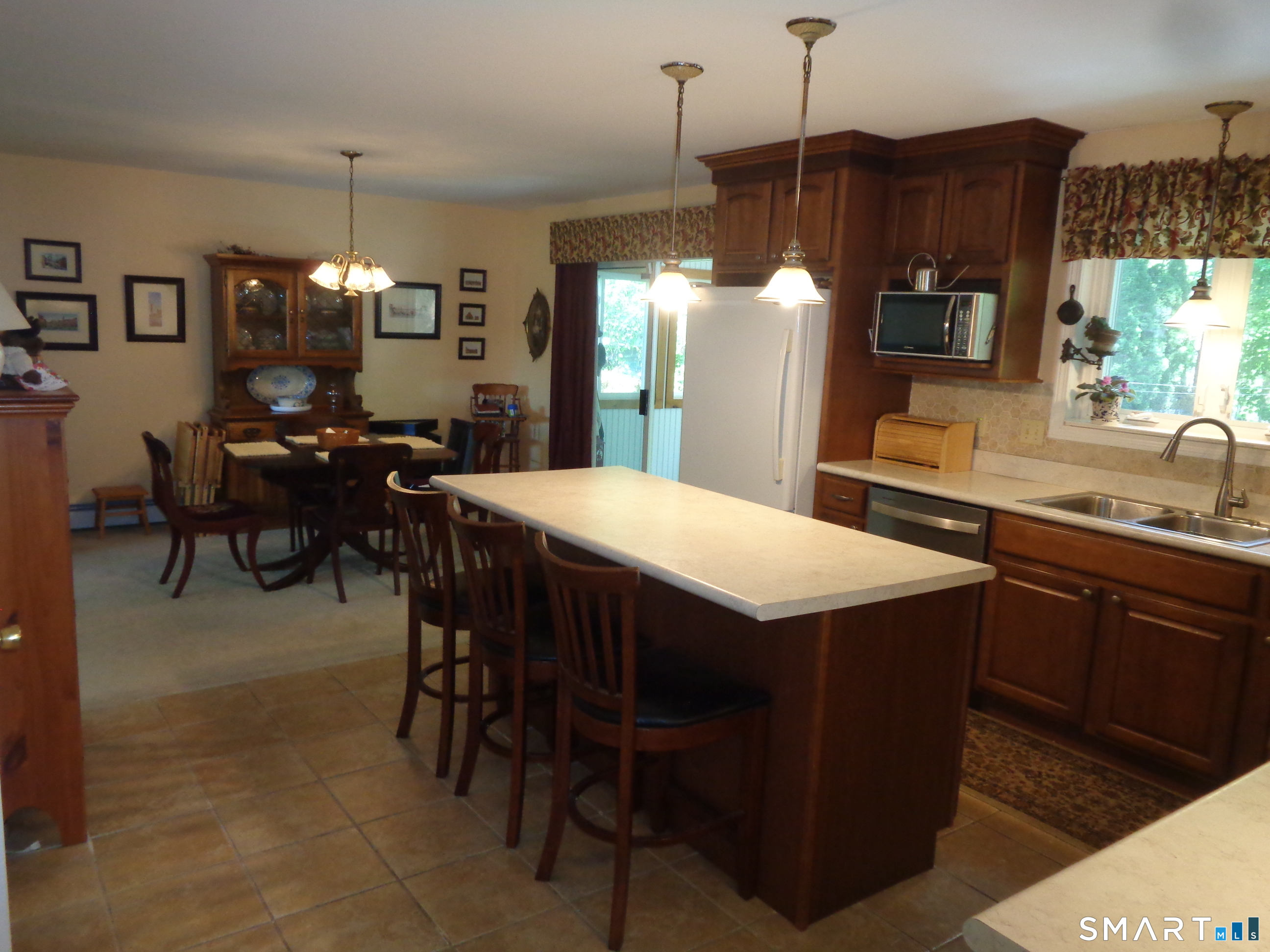 321 Spring Street Naugatuck, CT 06770 - Photo 4 of 27 a kitchen with a dining table chairs and white cabinets