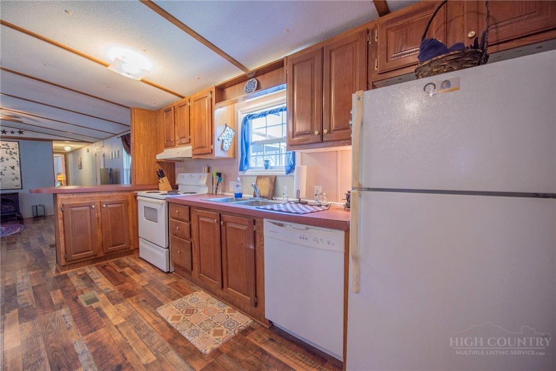 1848 West Mill Creek Road Warrensville, NC 28693 - Photo 23 of 50 a kitchen with a refrigerator a sink and cabinets