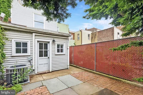 a view of a house with a door and wooden fence