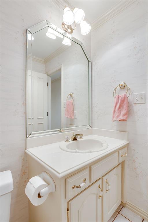 3068 High Ridge Drive Grapevine, TX 76051 - Photo 32 of 40 Beveled mirror with an ornate light fixture, vanity with integrated basin, decorative cabinet hardware, and crown molding