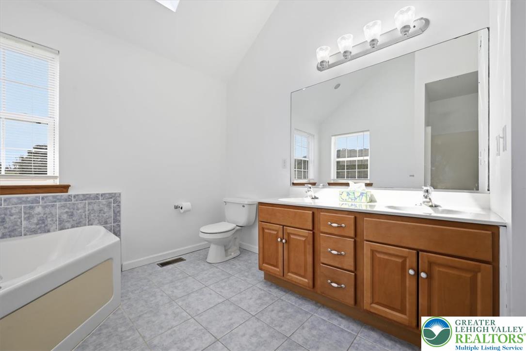 66 Labar Road Bangor, PA 18013 - Photo 24 of 56 A generous primary bath features a dual vanity and a deep soaking tub, all set on cool tile.
