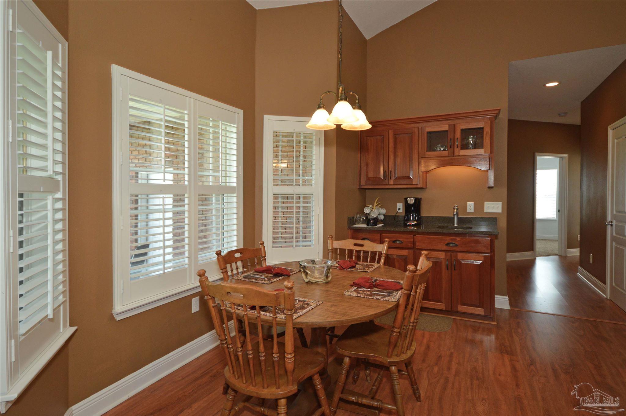 3478 Pine Level Church Road Jay, FL 32565 - Photo 23 of 50 a dining room with wooden floor a chandelier a wooden table and chairs