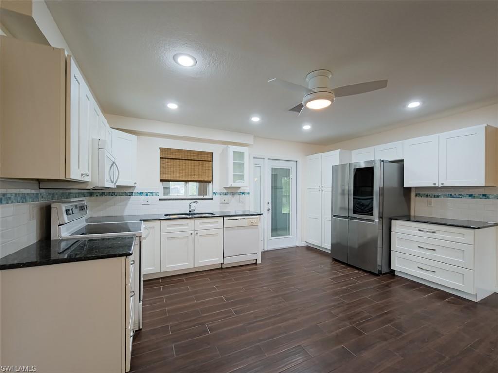 7425 Galloway Road Weeki Wachee, FL 34613 - Photo 4 of 23 a kitchen with white cabinets and stainless steel appliances