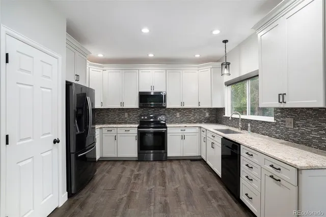 a kitchen with a refrigerator stove top oven and sink