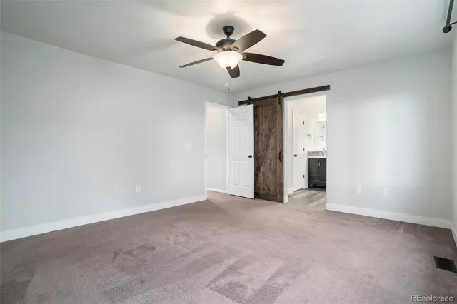 an empty room with closet and a ceiling fan