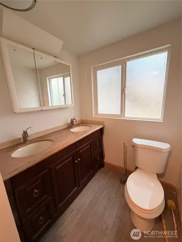 a bathroom with a double vanity sink and a toilet