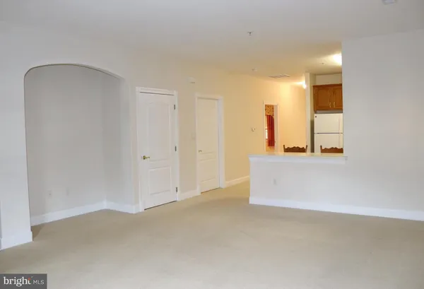 an empty room with a bathroom and mirror