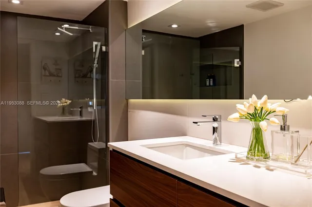 a bathroom with a sink a toilet and shower