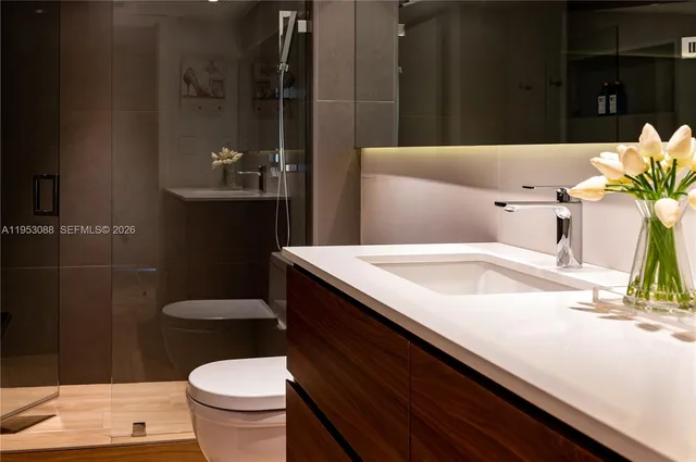 a bathroom with a sink a toilet and a shower