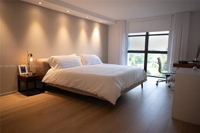 a bedroom with a bed and a large window