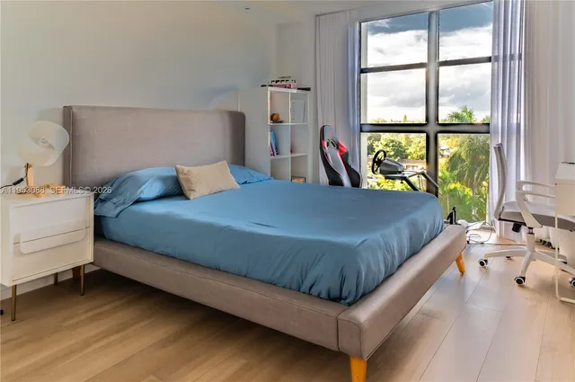 a bedroom with a bed and a large window