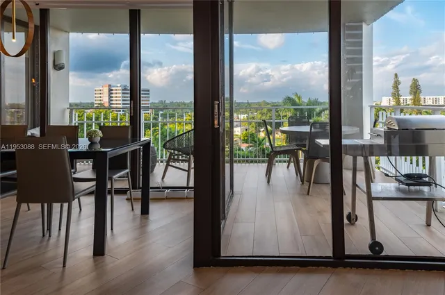 a dining room with floor to ceiling windows and wooden floor