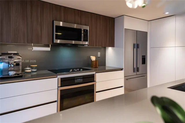 a kitchen with stainless steel appliances granite countertop a refrigerator stove and microwave