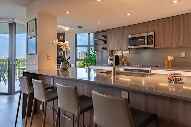 a kitchen with stainless steel appliances granite countertop a sink and a refrigerator