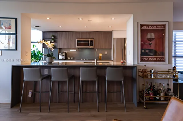 a kitchen with stainless steel appliances kitchen island granite countertop a table and chairs in it
