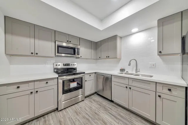 a kitchen with white cabinets sink and stainless steel appliances