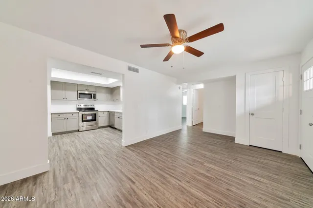a view of a livingroom with a ceiling fan and wooden floor