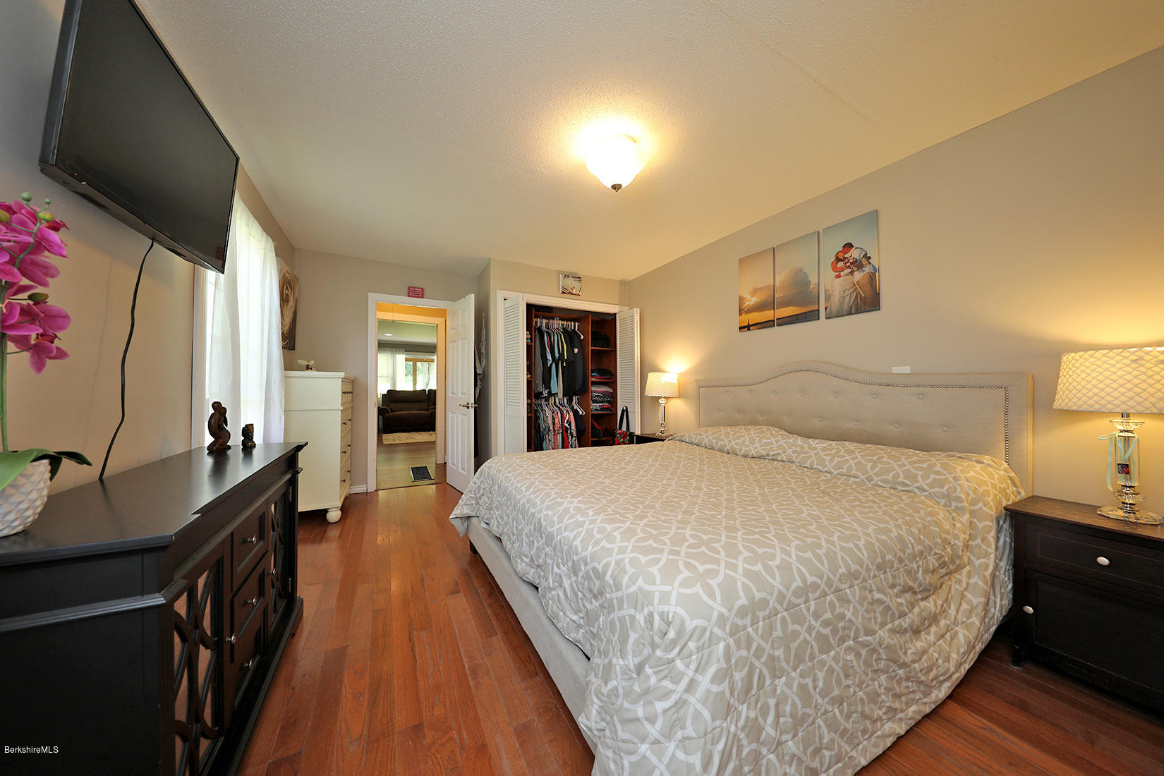 14 Ed Jones Road Otis, MA 01253 - Photo 17 of 28 a spacious bedroom with a bed and a flat tv screen on dresser