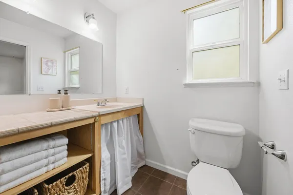 a bathroom with a granite countertop toilet sink and mirror